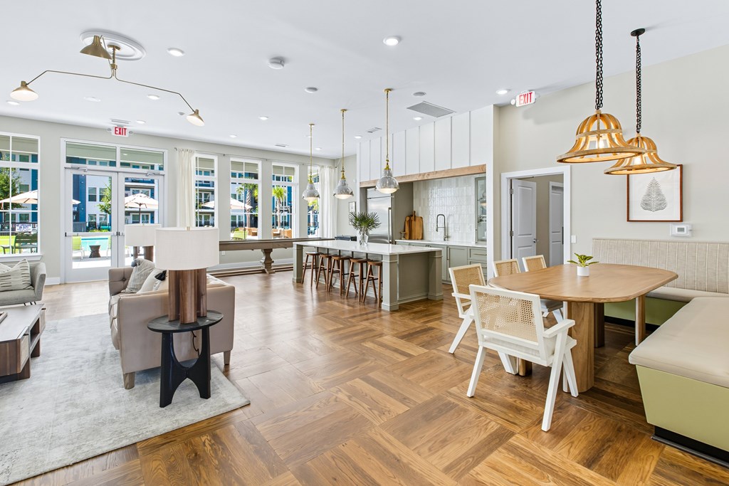 A modern living room with a dining area and a kitchen in the background.