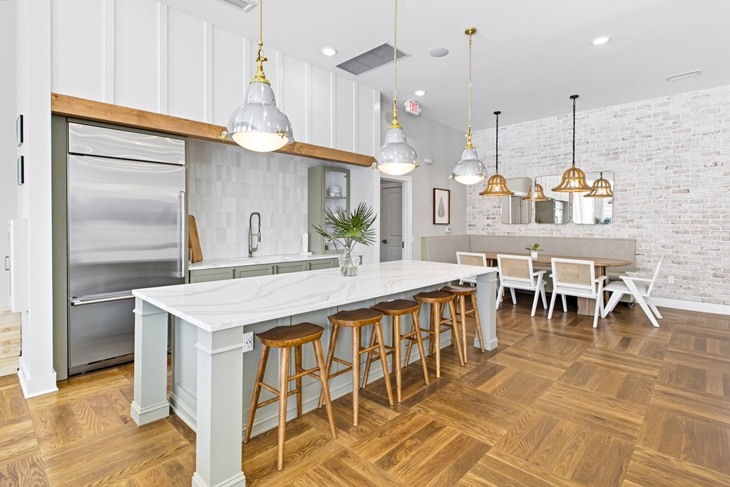 A kitchen with a white countertop and wooden floors.