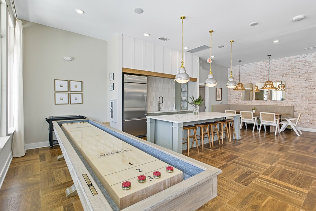 A shiny pool table is in the middle of a room with a bar and a dining table.