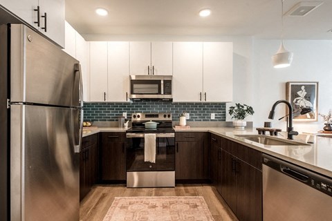 A modern kitchen with a stainless steel refrigerator and dark wood cabinets.