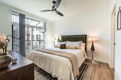 A bedroom with a large bed and a ceiling fan.
