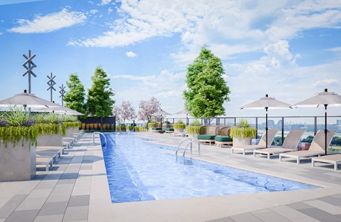 A large outdoor swimming pool surrounded by lounge chairs and umbrellas.