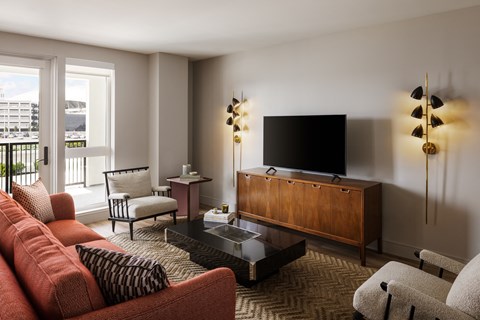 the living room of a hotel suite with a couch and a television