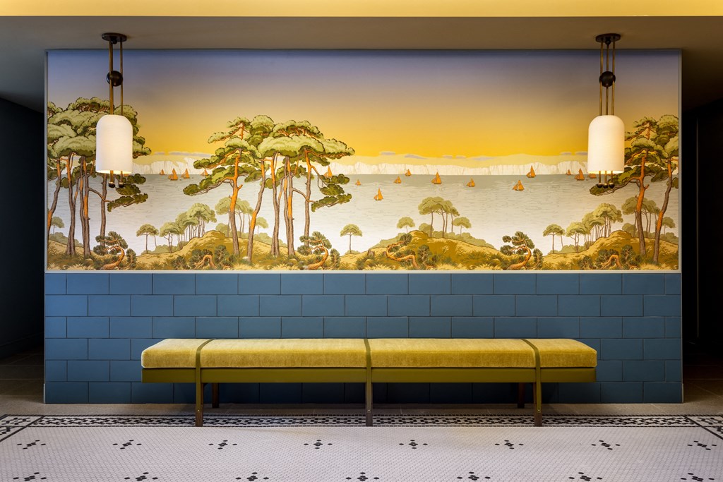 a bench in a room with a mural on the wall