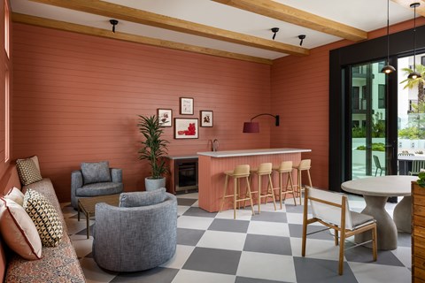 a living room with chairs and a bar and a checkered floor