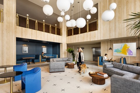 a woman walking her dog in a lobby of a hotel