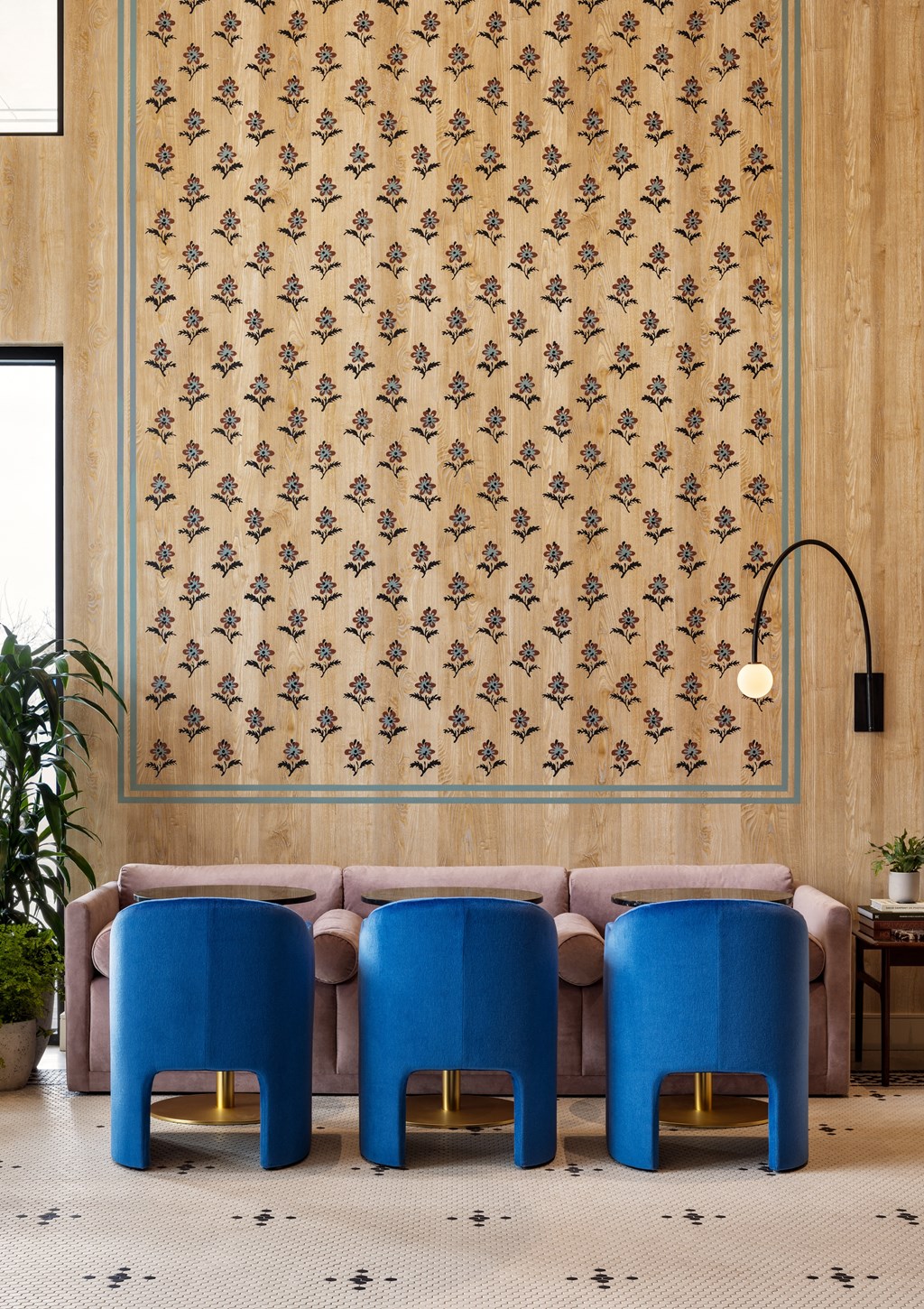 a living room with a pink couch and blue chairs