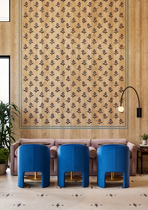 a living room with a pink couch and blue chairs