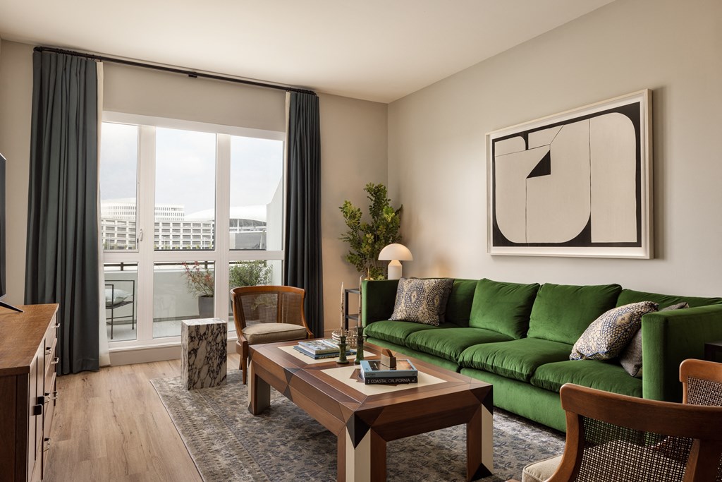 a living room with a green couch and a large window