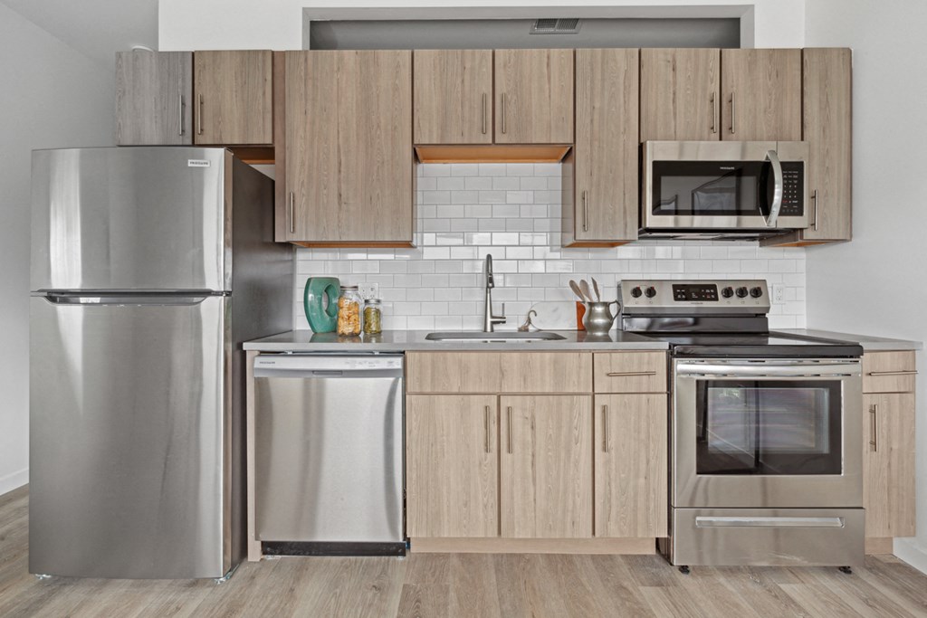 a kitchen with wooden cabinets and stainless steel appliances
