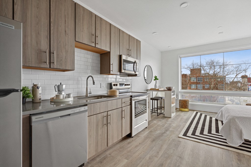 a kitchen with wooden cabinets and stainless steel appliances and a large window with a view of a