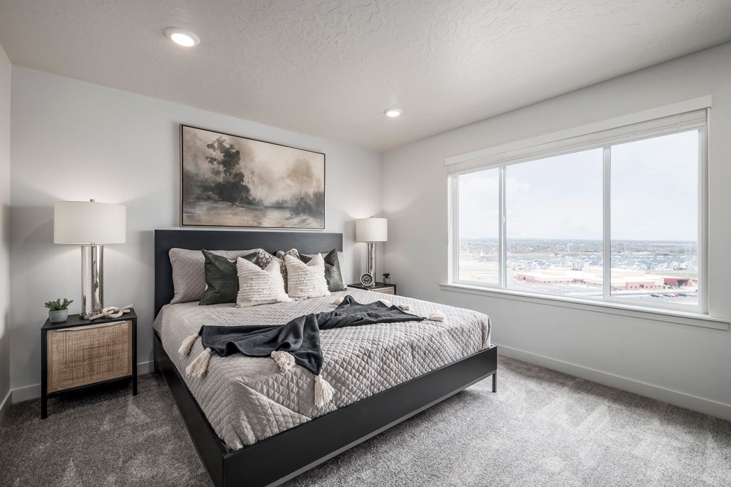 the master bedroom in a new home with a large window