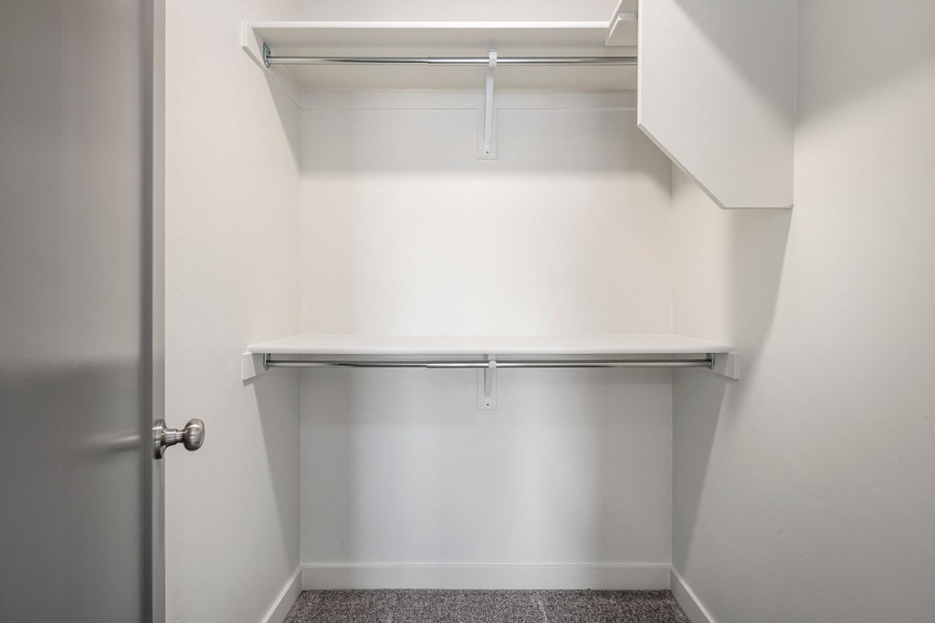 an empty closet in a home with white walls