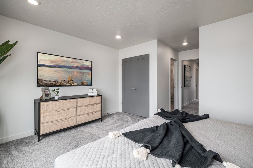 a bedroom with a bed and a dresser and a painting on the wall