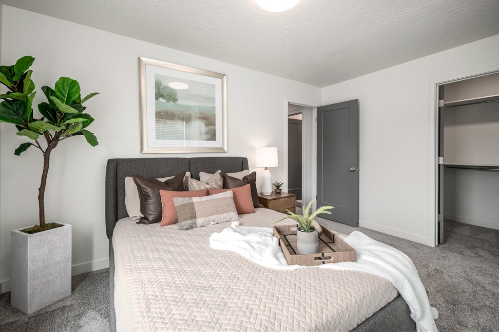 a bedroom with a large bed and a potted plant