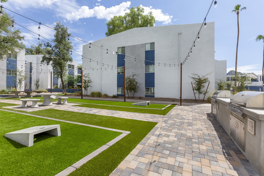A white building with a green lawn in front.
