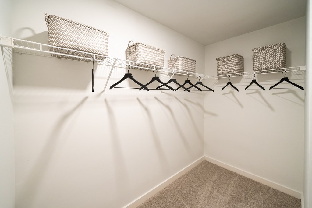 a spacious closet with shelves and hangers with chairs