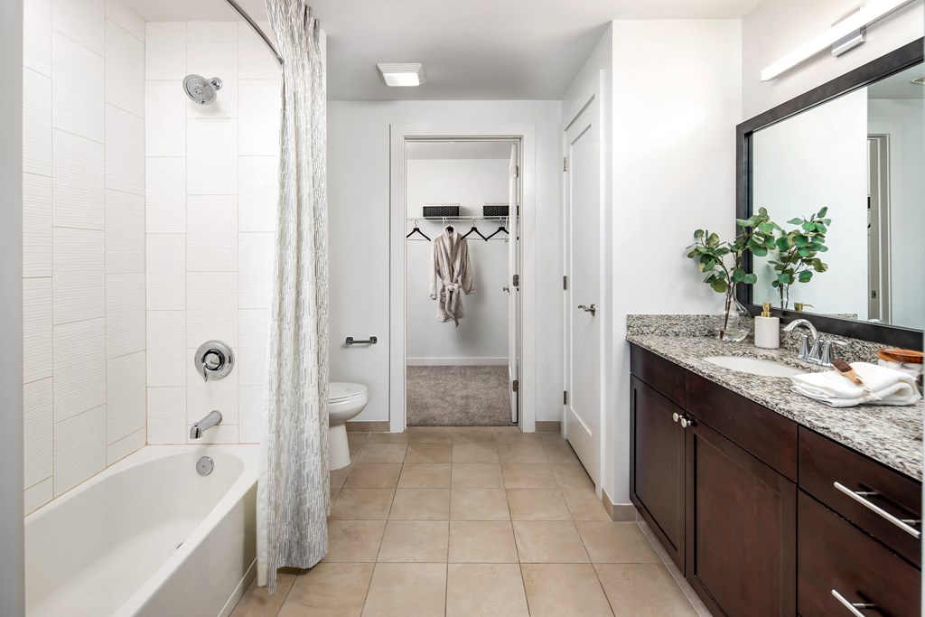 a bathroom with a tub and a shower and a sink