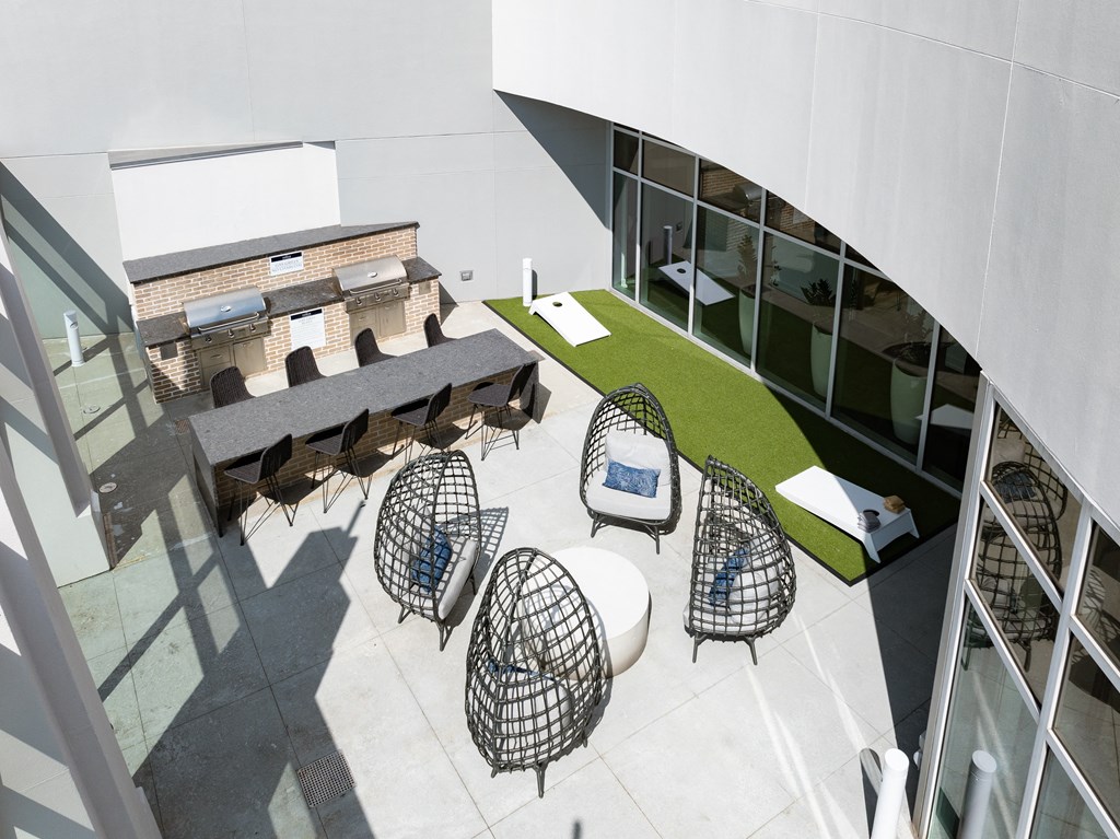 a courtyard with chairs and tables and a building in the background