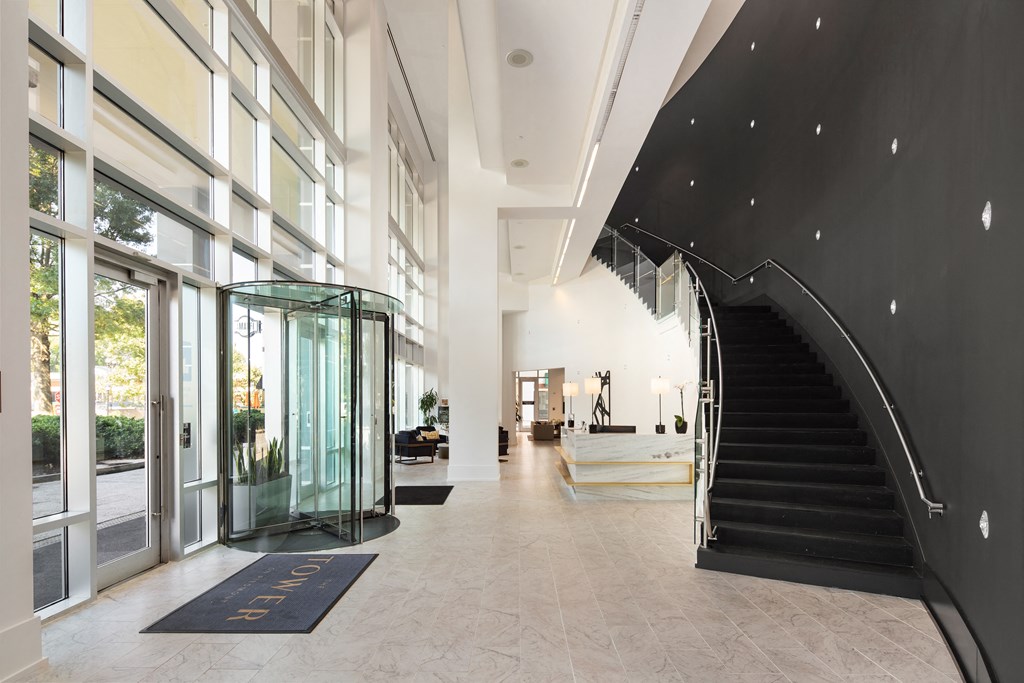 a large lobby with a black spiral staircase and glass doors