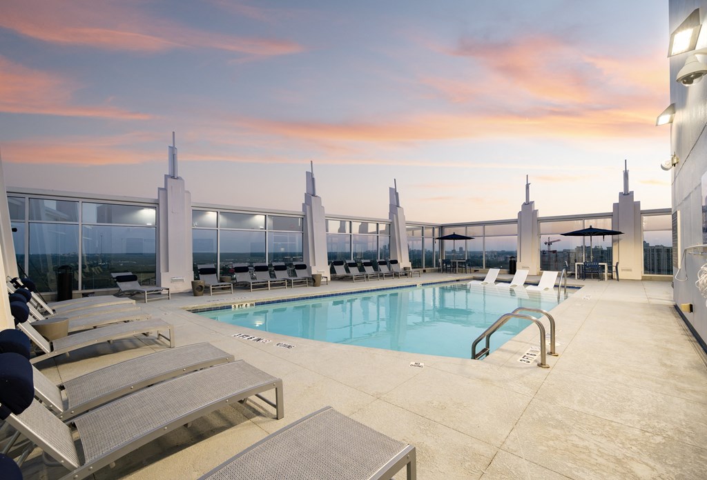 a swimming pool on the roof of a building at sunset