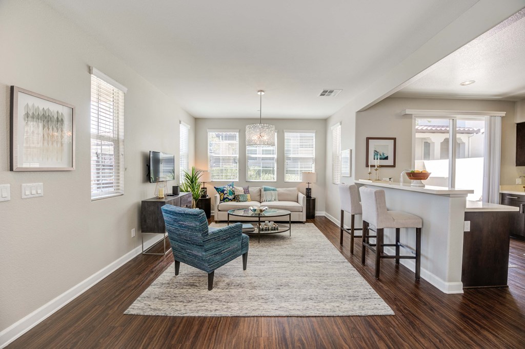 an open living room and kitchen with a bar and a living room with couches