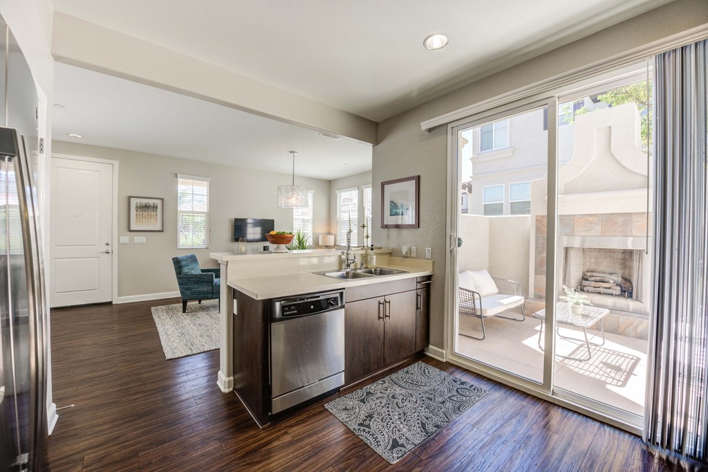 a kitchen with dishwasher and sink with sliding glass door