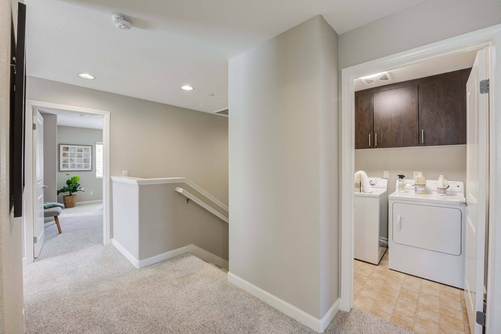 a utility room with a washer and dryer and a laundry room with stairs