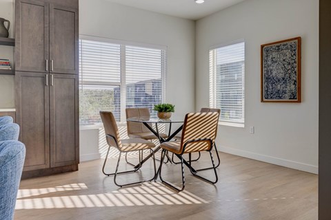 A dining room with a table and chairs.