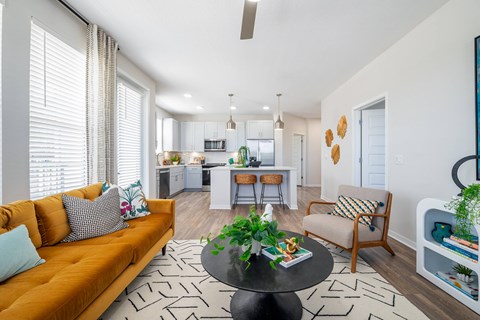 A living room with a sofa, a table, and a chair.at Corban Freedom Apartments, Florida