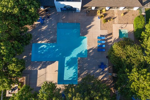 an aerial view of a swimming pool with a blue cross on it