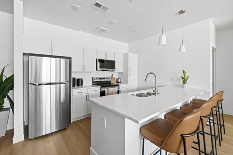 A modern kitchen with a stainless steel refrigerator and white countertops.