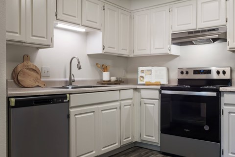 A kitchen with white cabinets and a black oven.