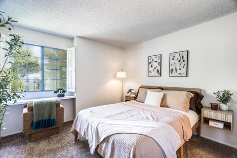 A bedroom with a large bed and a window with a view of the outside.