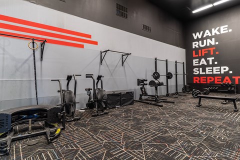 a gym with exercise equipment and a sign that reads wake run lift sleep