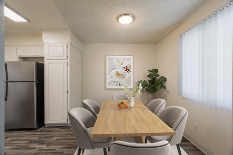 A dining room with a wooden table and chairs.
