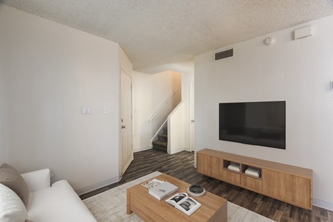 A living room with a staircase leading to the second floor.