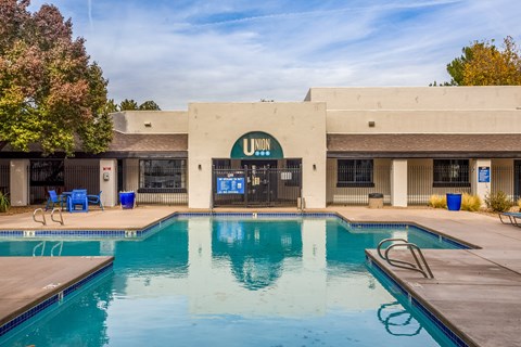 a swimming pool in front of a hotel with a building