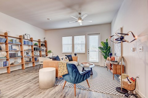 A living room with a blue chair and a bookshelf.