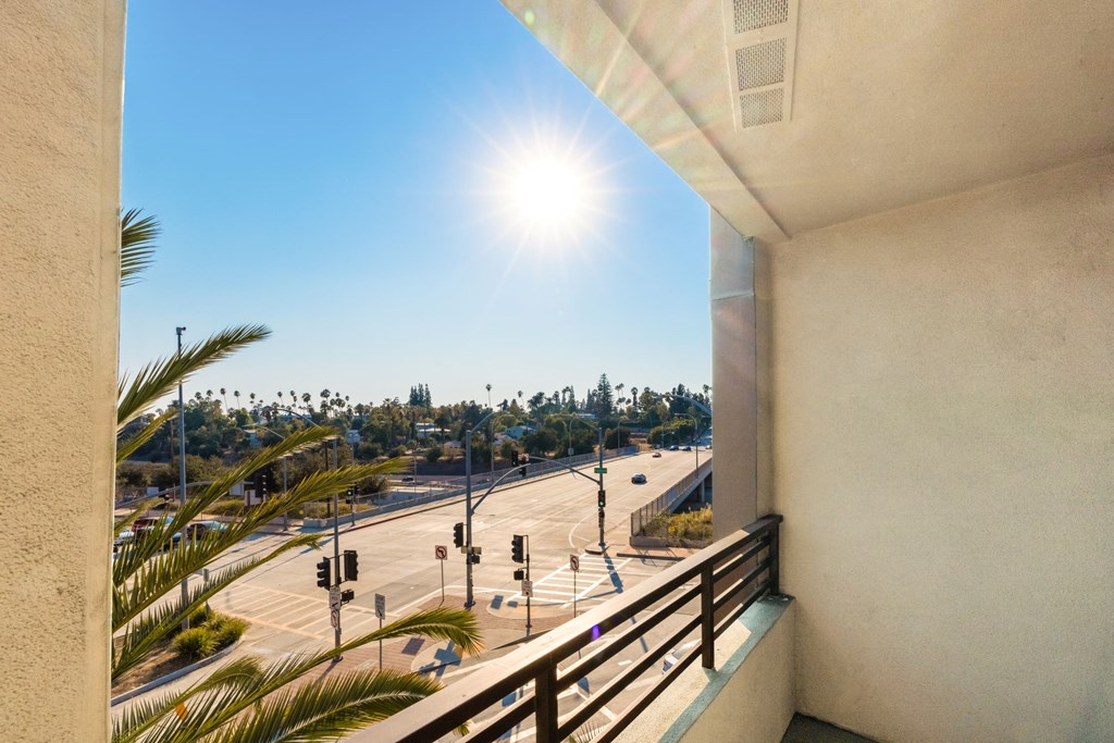 a balcony with a view of the freeway and palm trees