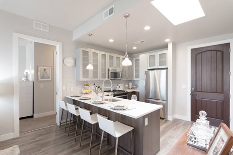 A modern kitchen with a long table and chairs.