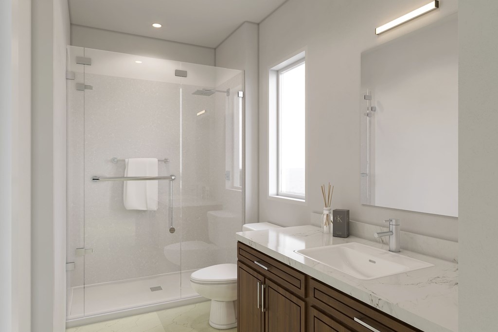 A white bathroom with a toilet, sink, and shower.