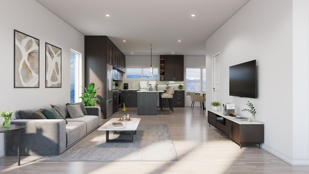 A modern living room with a grey sofa, a coffee table, and a flat-screen TV mounted on the wall.