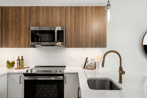 A modern kitchen with a black oven and a black microwave above it.