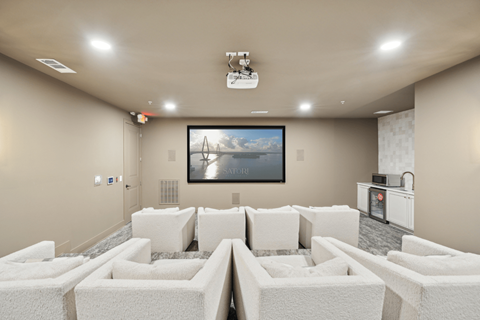 a large living room with white couches and a tv on the wall