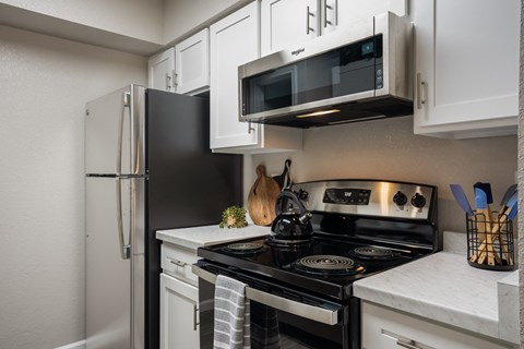 a kitchen with a stove and a microwave and a refrigerator