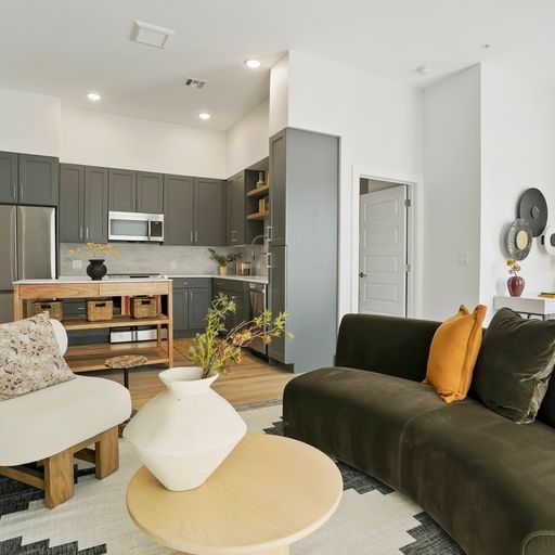 A modern living room with a grey couch and a wooden coffee table.