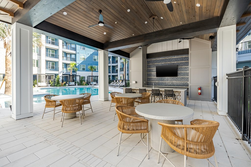A patio with a table and chairs and a television.