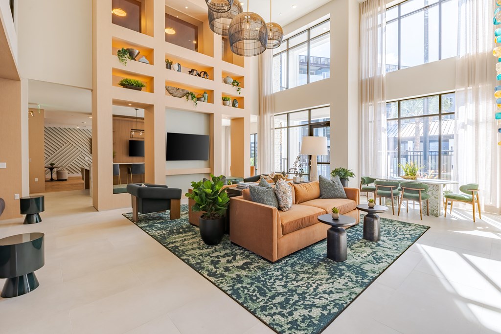 A living room with a large couch and a rug in the center.
