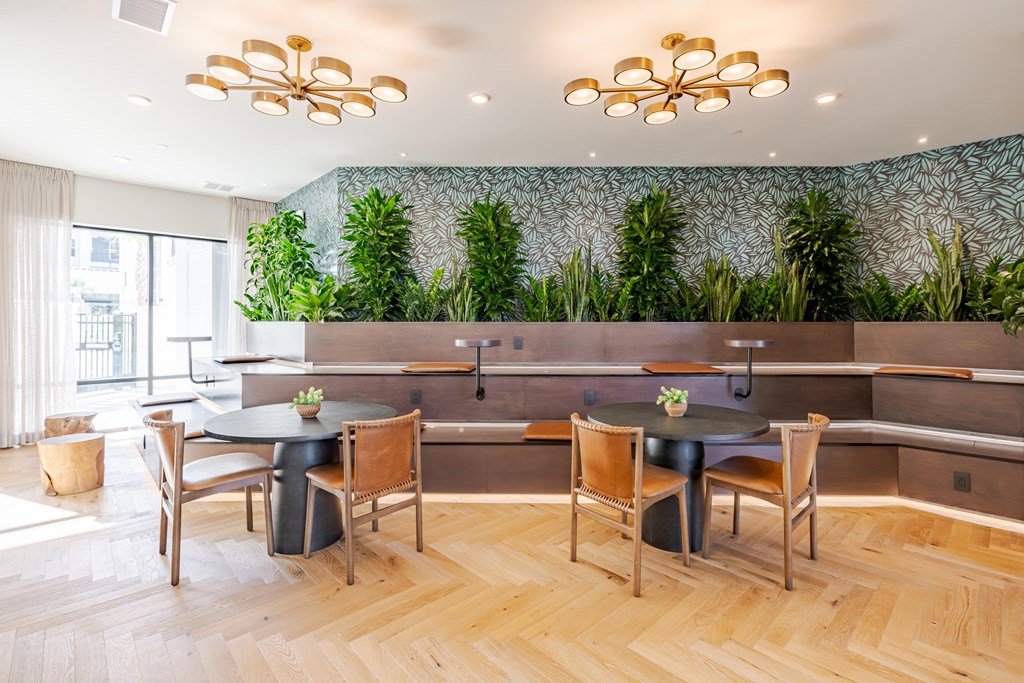 A dining area with a green wallpaper and wooden floors.